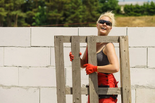木造ユーロパレットを保持する建設現場でいくつかの仕事をしようとする女性 — ストック写真