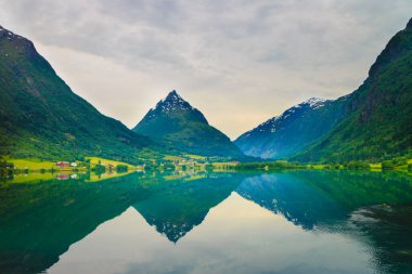 Tourism and travel. Reflection of mountain in water fjord lake, Sogn og Fjordane county. Norway Scandinavia. clipart