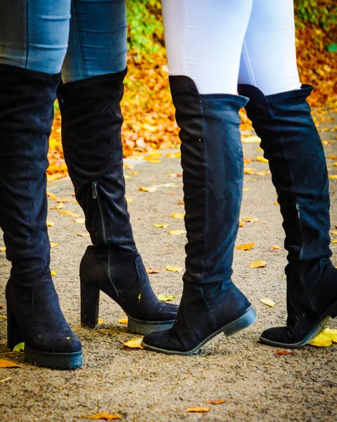長い黒のかかとの高い膝の高いブーツとジーンズを身に着けている2人の認識できない女性 秋のファッション 暖かい履物のブーツ — ストック写真