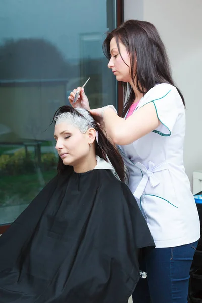 放松和理发的概念 穿着黑色斗篷的女人在美容院里给自己的头发涂上了护发素 — 图库照片