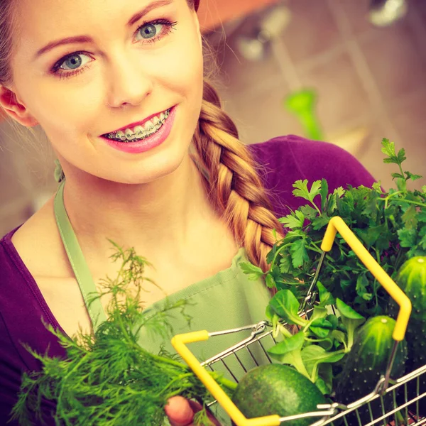 健康的な食事の概念を購入する 台所の女性は多くの緑の野菜を持っている小さなショッピングバスケットトロリー — ストック写真