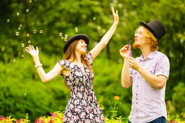 Happy Funny Hipster Couple Playing Together Blowing Soap Bubbles Outdoor — Stock Photo, Image