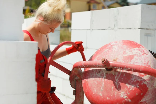 在房屋建筑现场与红色混凝土搅拌机一起工作的女强人 工业工作设备概念 — 图库照片
