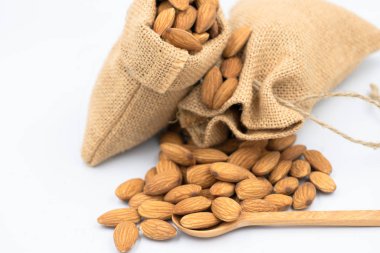 Tahta kaşık ve kırık tohum dış badem tohumları. Dokuma Çuval üzerinde grup badem. Odak alan sığ derinliği seçin