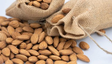 Dokuma çuval ve taşma grup badem tohumları. Odak alan sığ derinliği seçin.