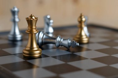 Gemide satranç ayarla. Altın Kraliçe bulunur ve Gümüş Kral aşağı düşüyor. Odak sığ alan derinliği ve arka plan bulanık seçin. Kavram çalışmaları