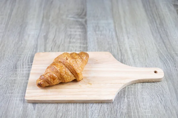 Pedaço Croissant Colocado Uma Placa Corte Madeira Mesa Madeira Cinza — Fotografia de Stock