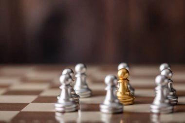 Altın satranç oyuncusu, tahtadan bir arka planla güvertede duruyor.