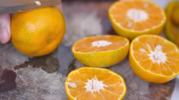 台所のまな板の上でオレンジを半分に切る — ストック動画