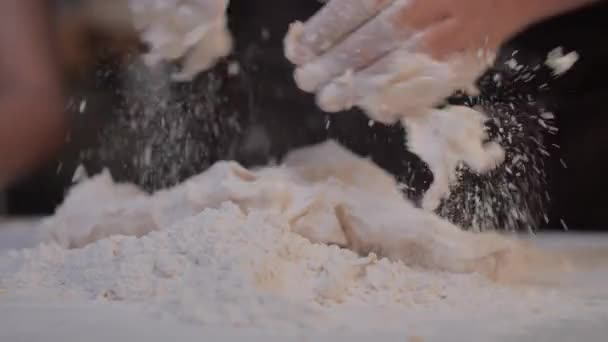 手を閉じて白いテーブルの上にパン屋を作るために生地をこねている — ストック動画