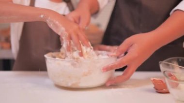 Anne ve kızı karıştırma kabındaki unu karıştırıp ev yapımı bir fırın yapmalarına yardım etti.