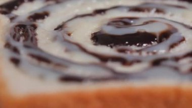 Çikolata ve konsantre sütü bir parça ekmeğin üzerine yakın plan çek.