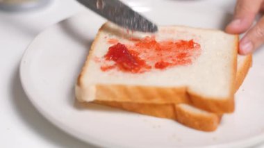 Bir dilim ekmeğe çilek reçeli sür..
