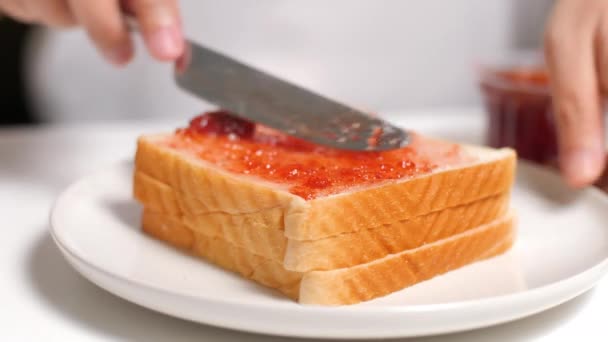 把草莓果酱涂在一片面包上 — 图库视频影像