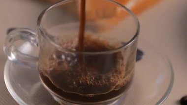 Yakın plan bir bardağa koyu kahve dök.