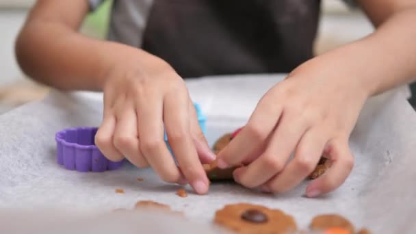 テーブルの上に手作りクッキーを作る小さなアジアの女の子のクローズアップ手 — ストック動画