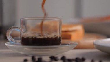 Yakın plan bir bardağa koyu kahve dök.