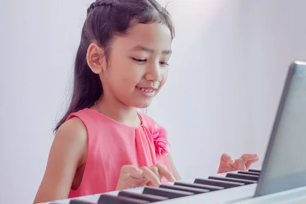 Seorang Gadis Asia Kecil Bermain Keyboard Putih Dengan Kebahagiaan Anak — Stok Foto