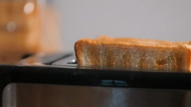 Kadınlar kahvaltıda ekmek kızartma makinesinden ekmek çıkarıyorlar..