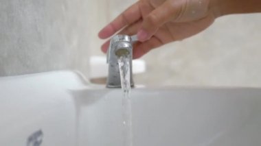 Beyaz lavaboda yemek yemeden önce yakın plan kadın ellerini yıkıyor.