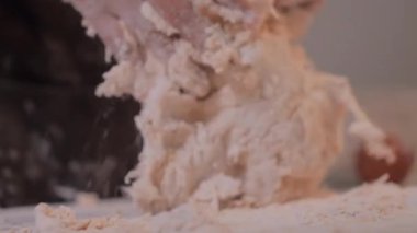 Yakından bakınca, beyaz masadaki hamuru yoğuruyorlar.