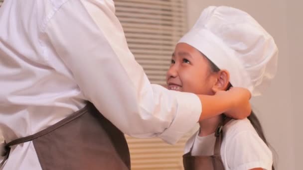 Mãe Usa Chapéu Chef Branco Para Sua Filha Abraços — Vídeo de Stock