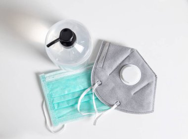 Üst manzara, N95 ve beyaz masada el dezenfektanı jeli cerrahi maskeler. Coronavirus veya COVID-19 salgınından koru. yayılım koruması.