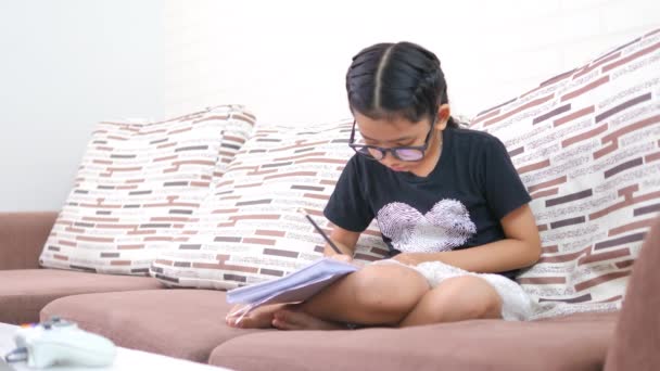 Asian Little Girl Sat Sofa Wrote Something Paper — Stock Video