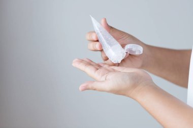 Kadının elleri, mikropları temizlemek ve öldürmek için tüpteki alkol jelini avuç içine sıkıyor. Coronavirus veya COVID-19 için koruma.