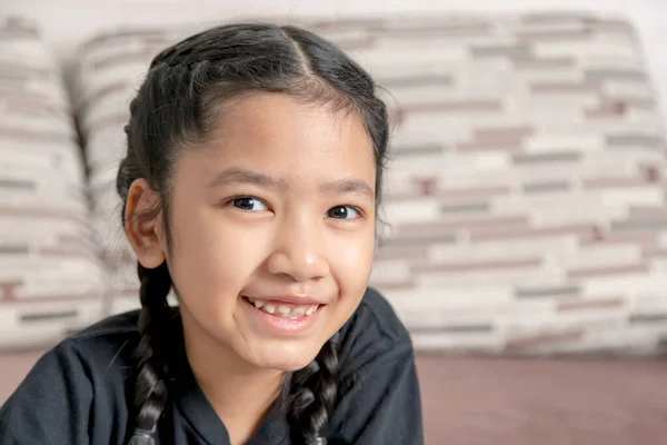 Seorang Gadis Asia Kecil Dalam Kepang Hitam Tersenyum Sofa — Stok Foto