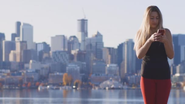 Giovane Donna Adulta Sms Sul Cellulare Città Skyline Edifici Waterfront — Video Stock