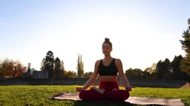Çimen Parkı 'nda Yoga Mat' te Rahatlayan Kadın Gerginliği ve Zihnindeki Düşünceli Sezgiyi Rahatlatmak İçin Nefes Alma Egzersizi Yapıyor