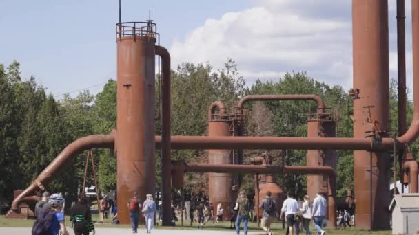 シアトルワシントン6月2019ガス工場公園で象徴的な工業用地の下を歩く人々晴れた日 — ストック動画