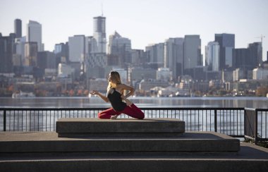 Kadın Yoga Eğitmeni Şehir merkezindeki Rıhtımda Tek Ayaklı Kral Yoga Pozu Yapıyor