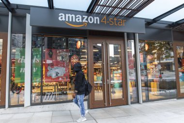 Seattle, Washington ABD - 2 Aralık 2019: Kapüşonlu ve Eldivenli Adam Amazon 'un 4 yıldızlı mağazasının dışında yürüyor