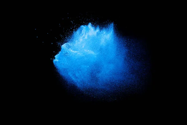 Blue color powder explosion cloud on black background.Closeup of Blue dust particles exhale on dark background.