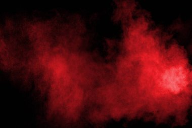 Siyah zemine serpilmiş soyut kırmızı toz, patlayan kırmızı renk tozunun dondurucu hareketi.