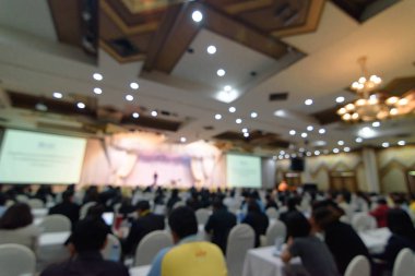 Konferans salonunda ya da seminer odasında iş adamlarının bulanık bir fotoğrafı var. Toplantı odası konseptinde odaklanmamış insanlar.