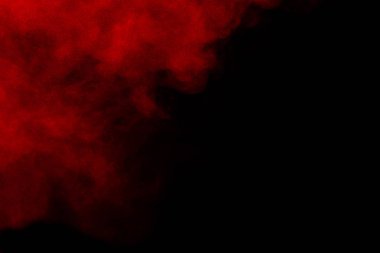 Siyah zeminde kırmızı renk tozu patlaması. Kırmızı toz parçacıklarının hareketsiz durması..