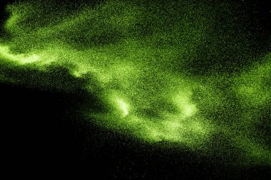 Green dust particles explosion on black background. Powder dust splash.