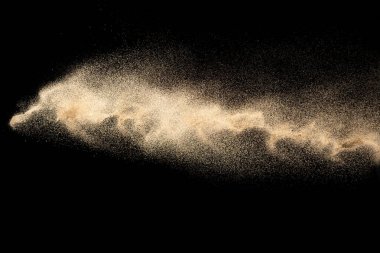Kahverengi kum sıçraması. Kuru nehir kumu patlaması. Siyah arka planda izole edilmiş. Soyut kum bulutu.