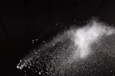 Beyaz tuhaf formları patlama bulut siyah arka plan karşı toz. Beyaz toz parçacıkları sıçrama.