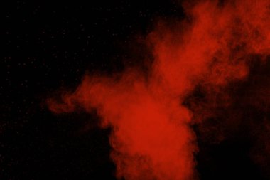 Siyah zeminde kırmızı renk tozu patlaması. Kırmızı toz parçacıklarının hareketsiz durması..