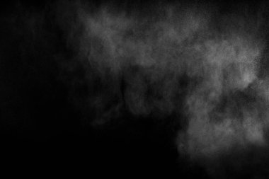 Siyah zemine karşı soyut beyaz toz patlaması. Havada beyaz toz esiyor..