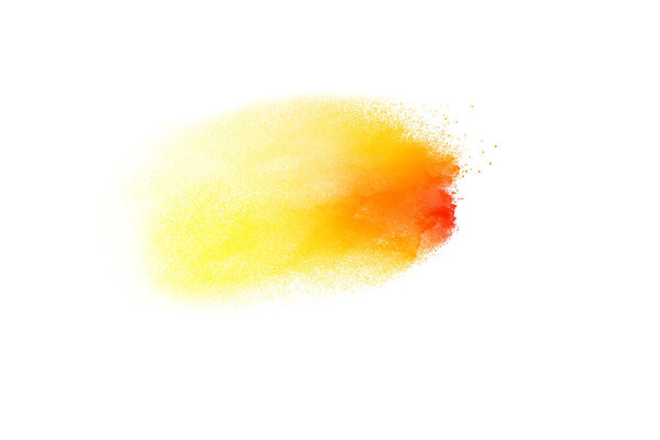 Yellow orange color powder splatter on white background. Color particles splash