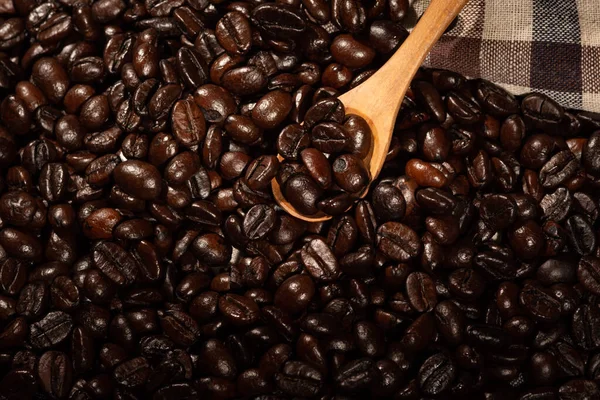 Närbild Bruna Rostade Kaffebönor Trä Sked Bakgrund — Stockfoto