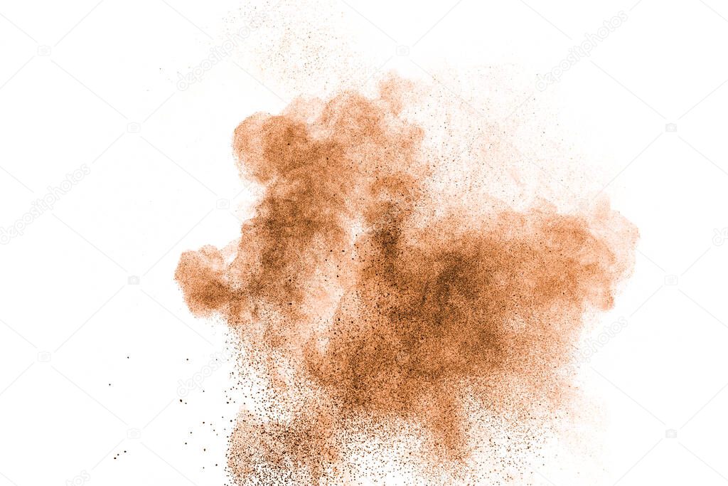 Abstract brown powder splattered on white background.Abstract design of color dust cloud against white background.