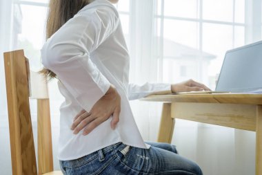 Sırtına masaj yapan, acı çeken bir kadın..