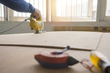 Büyük bir tahta kesmek için elektrikli testere kullanmak..