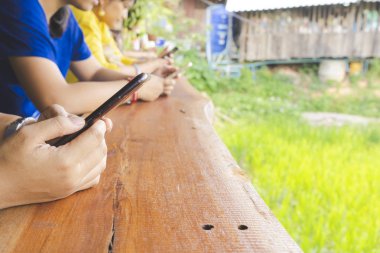 Akıllı telefon kullanan bir grup çok kültürlü arkadaş.